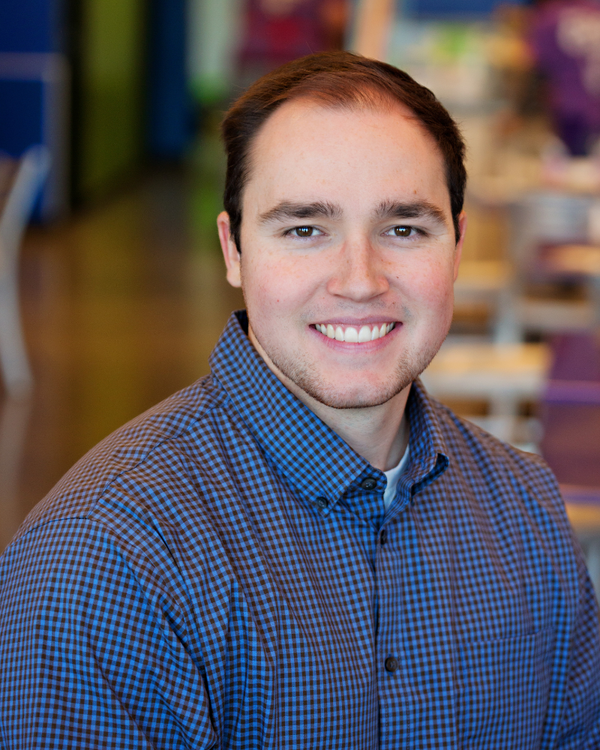 Man wearing a blue checkered shirt in an indoor setting